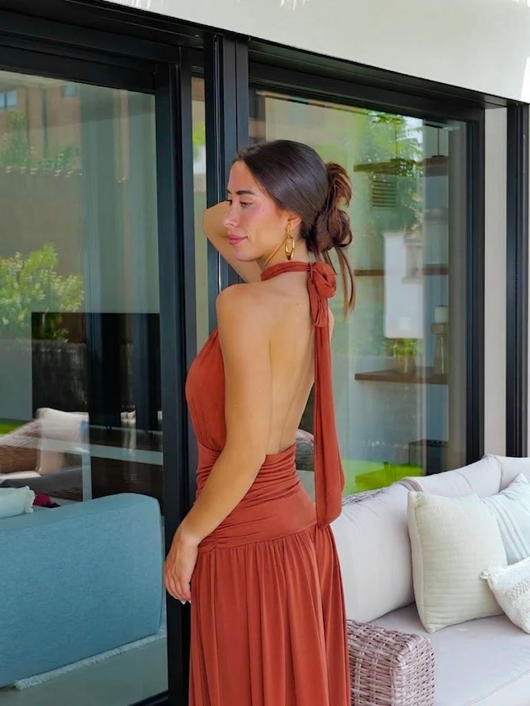 Vestido com decote halter e drapeado, com costas em forma de caldeira