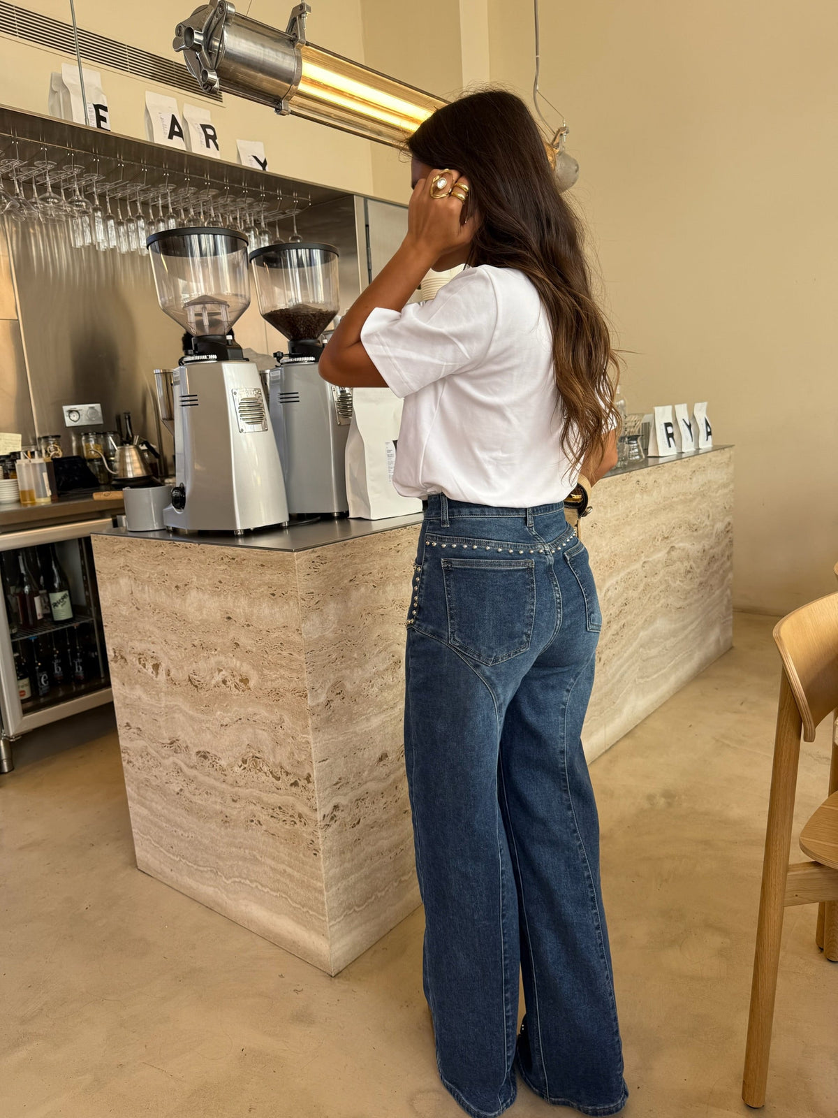 Calça jeans de perna larga com detalhes de tachas